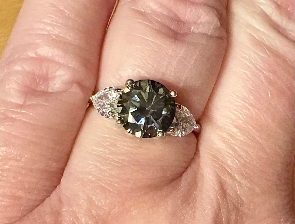 Moissanite ring. A 3ct certified GRAY Moissanite with 1.5cttw of heart-cut white zircons, set in a sterling silver basket 3-stone design!