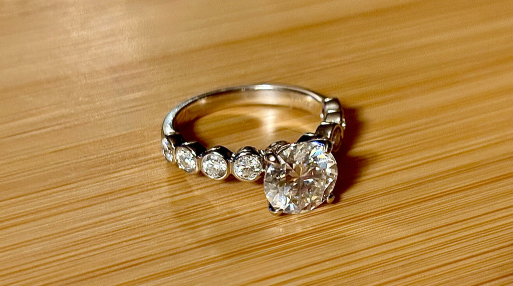 A 3.8cttw designer Moissanite ring with a certified 3ct center stone and 10-point bezel-set stones in sterling silver and 18k gold!