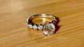 A 3.8cttw designer Moissanite ring with a certified 3ct center stone and 10-point bezel-set stones in sterling silver and 18k gold!