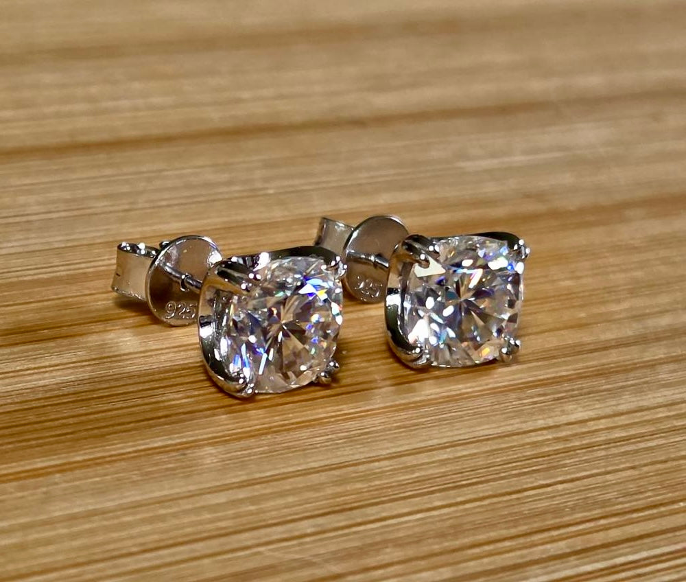 6ctw cushion-cut Moissanite studs in elegant sterling silver double-claw mountings! With brilliant faceting, these earrings are showstoppers!