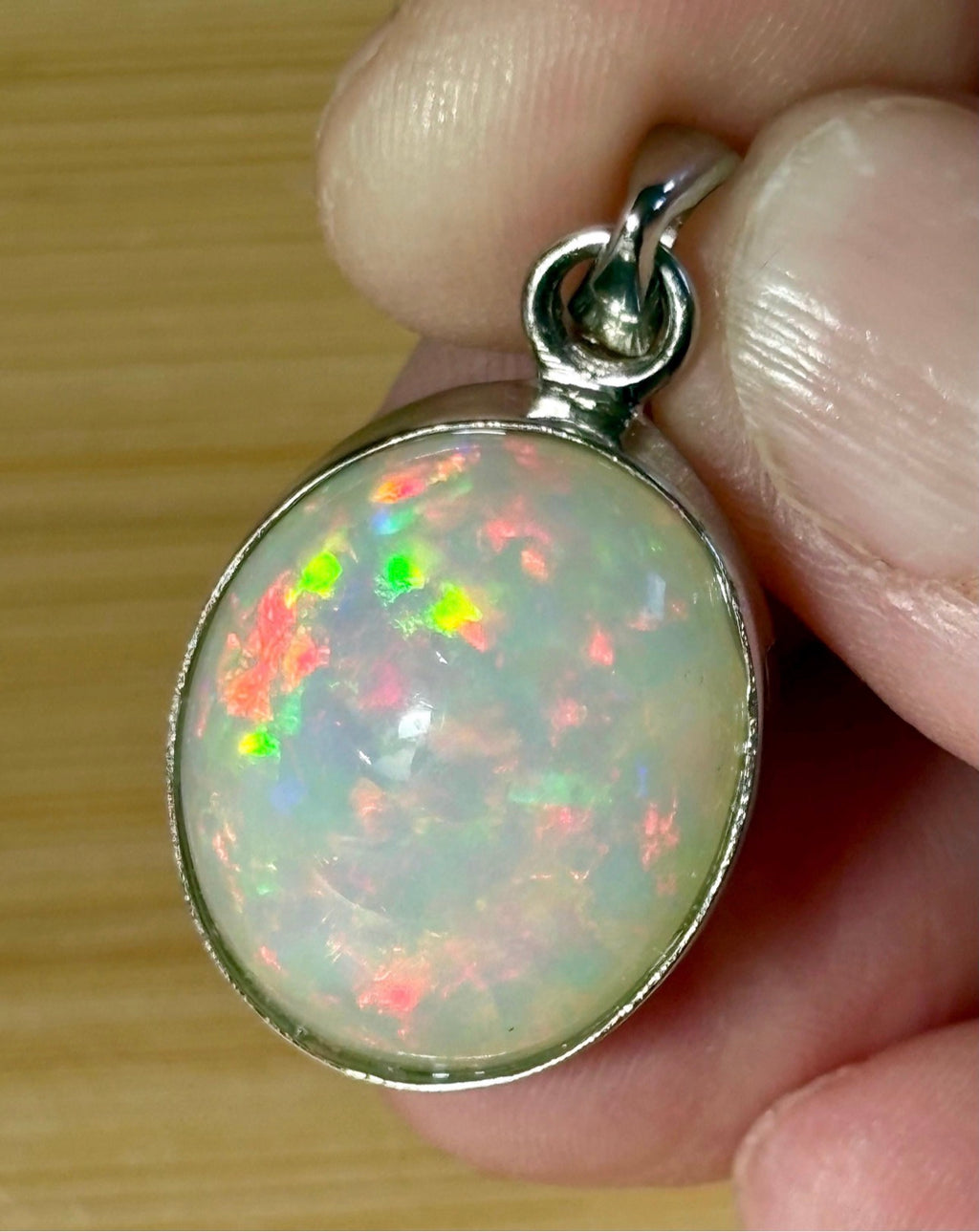 A 17.28ct AAA grade Ethiopian opal pendant with multi-patterned fire and beautiful play of color, hand-picked by Hand Knotted Jewelry!