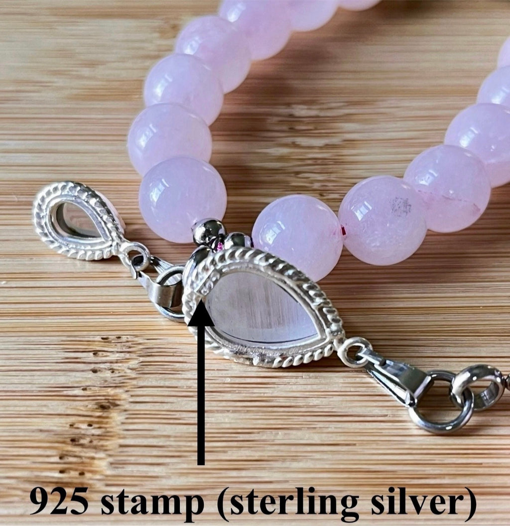 Madagascar rose quartz bracelet. 10mm beads with stainless steel components. The featured sterling silver pendants are sold separately.