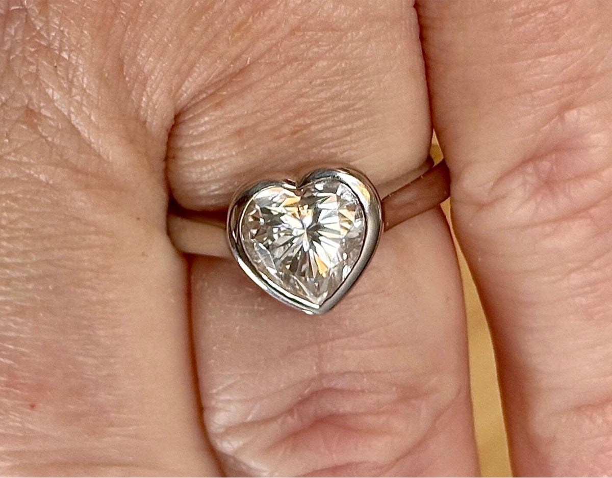 Moissanite ring. A high-end solitaire with a certified 3ct heart-cut stone, bezel-set in a heavy sterling silver mounting and bathed in 18k!