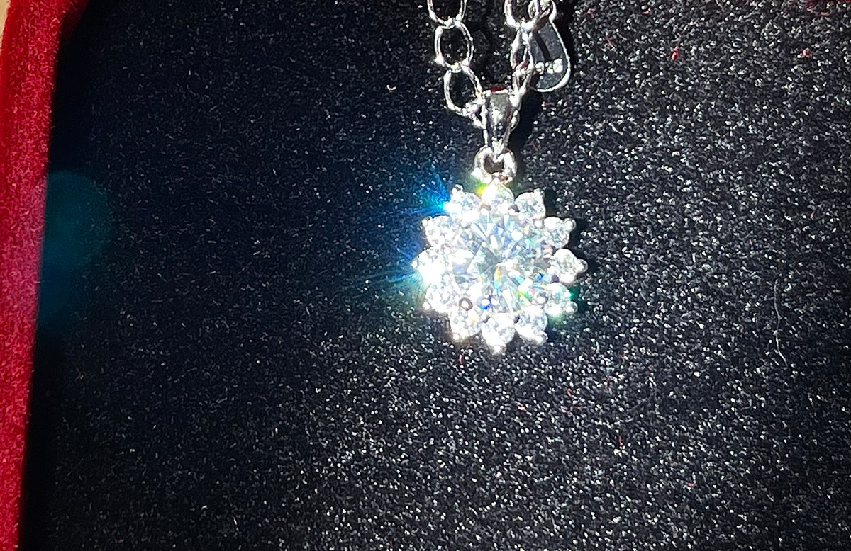 Moissanite necklace. A 1ct or 3ct Moissanite in a halo of sparkling white zircons (I call it the “Sunflower” pendant)! In sterling silver and 18k!