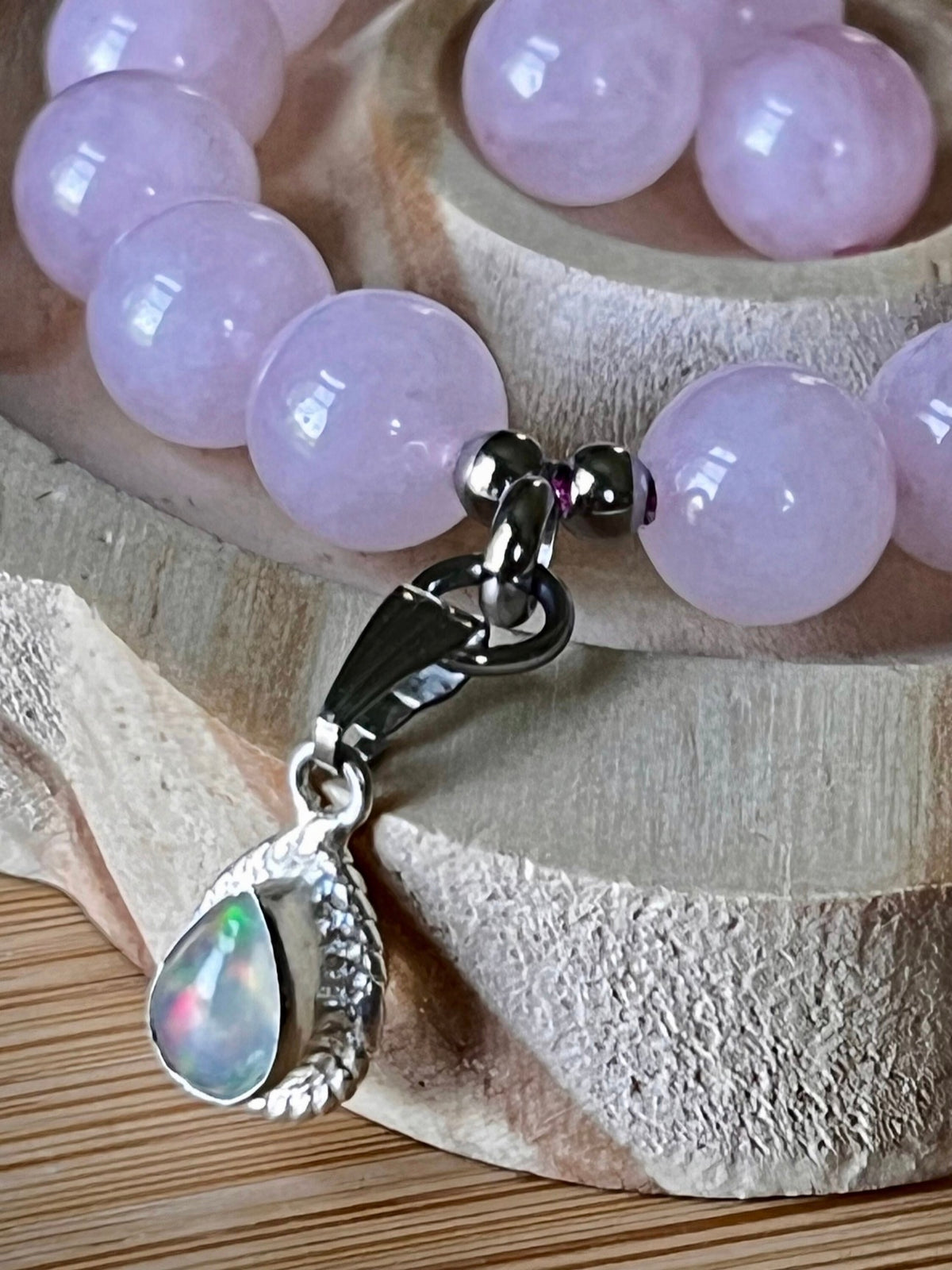Madagascar rose quartz bracelet. 10mm beads with stainless steel components. The featured sterling silver pendants are sold separately.