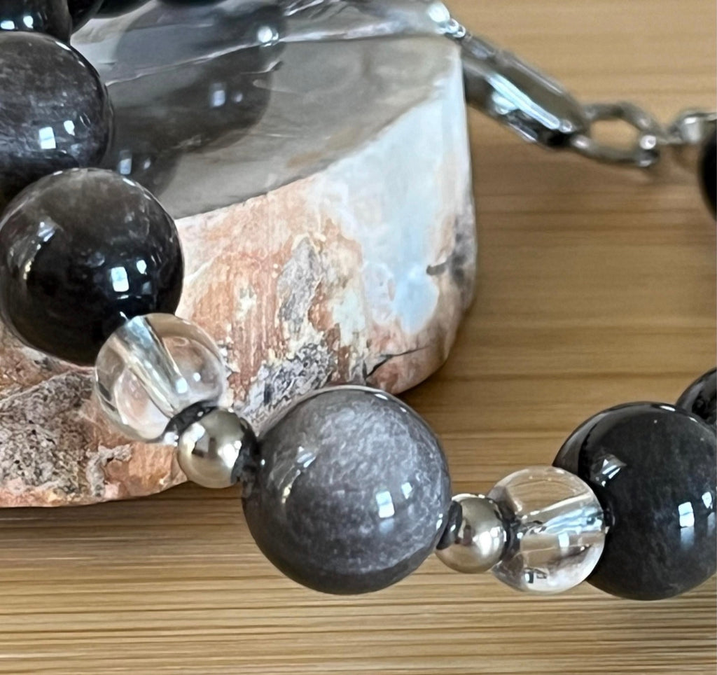 Silver sheen obsidian and clear quartz bracelet and earrings. Pair the “Silver Bells” bracelet and/or earrings with your little black party dress and be the Belle of the Ball!