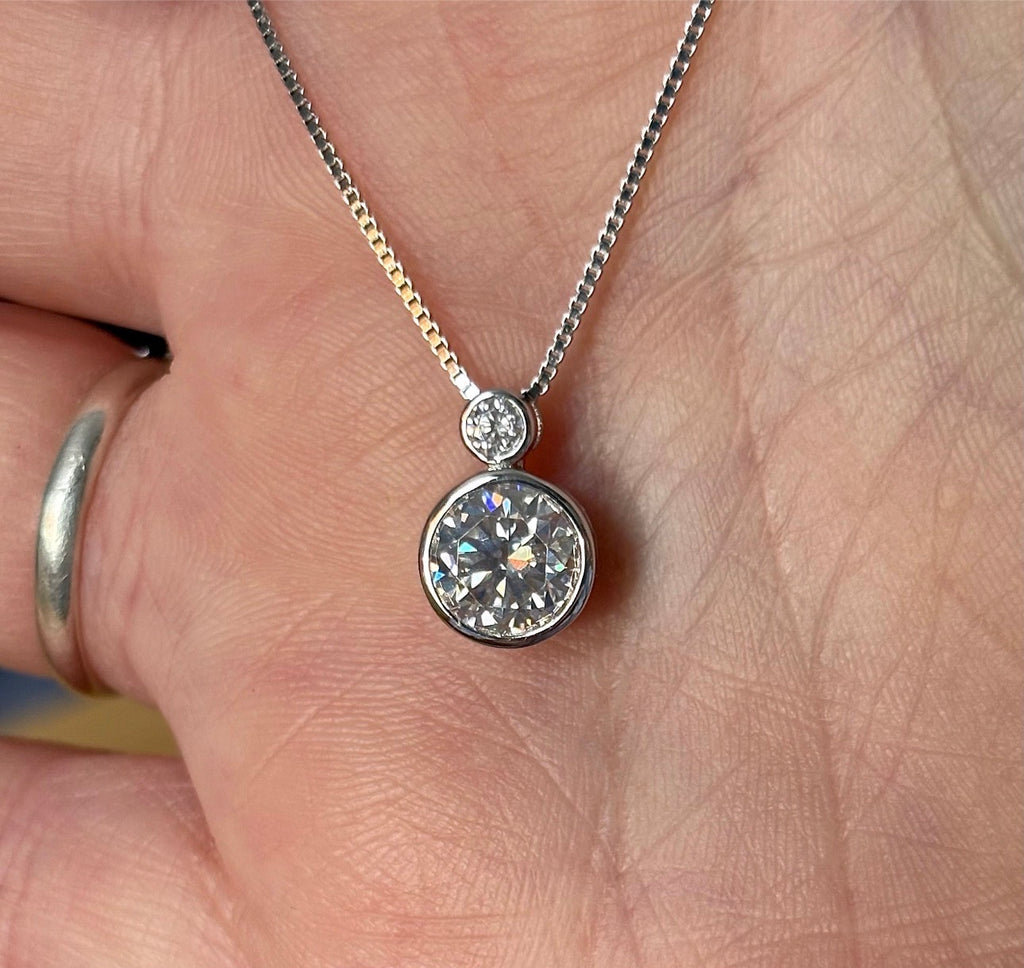 Moissanite necklace. A bright 2.1ctw certified Moissanite bezel pendant, with a 18” box chain and lobster claw clasp in sterling silver!