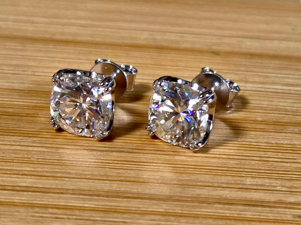 6ctw cushion-cut Moissanite studs in elegant sterling silver double-claw mountings! With brilliant faceting, these earrings are showstoppers!