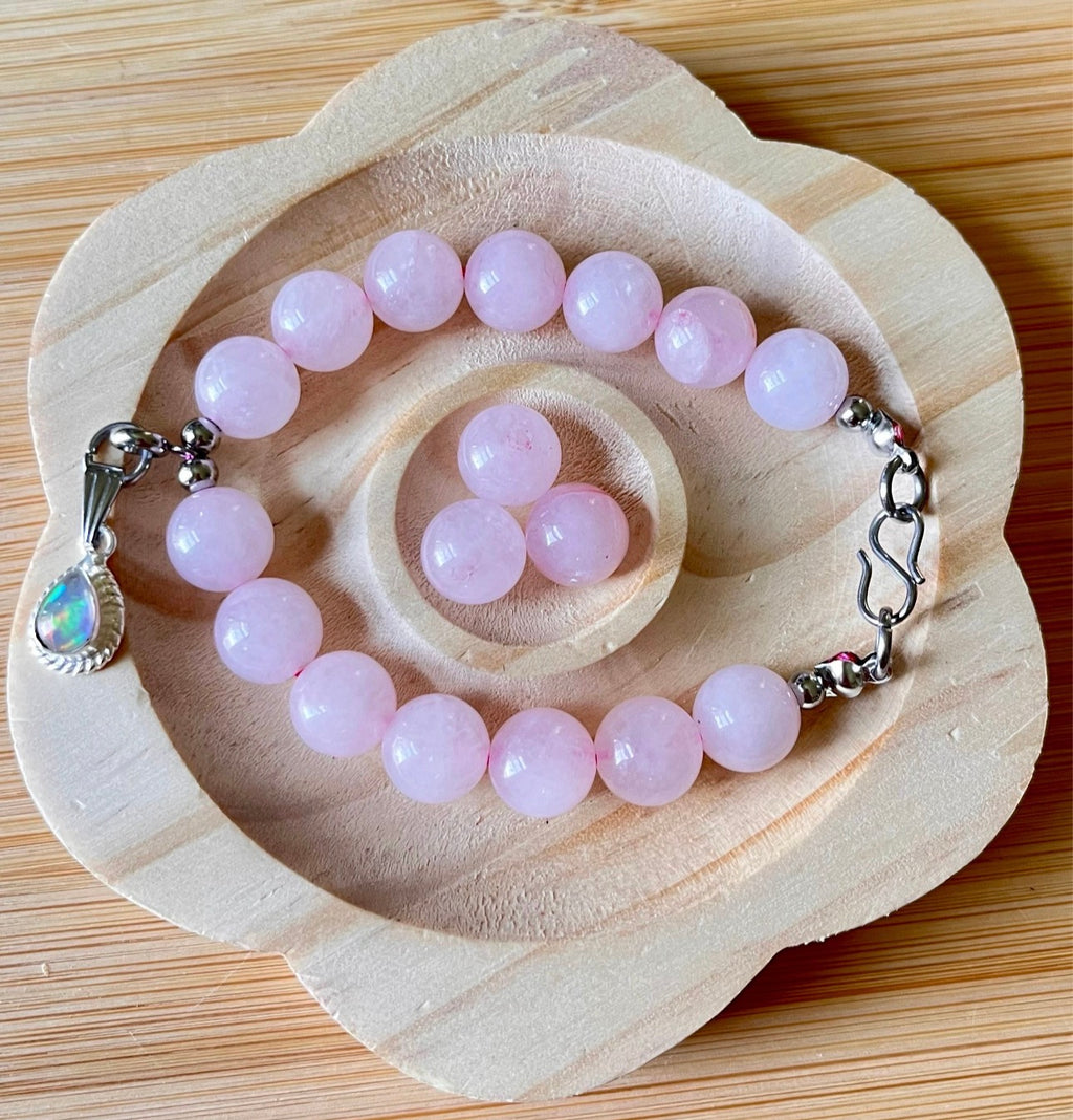 Madagascar rose quartz bracelet. 10mm beads with stainless steel components. The featured sterling silver pendants are sold separately.