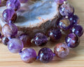 Super seven amethyst bracelet. AAA-grade 12mm “super seven”, mineral name cacoxenite amethyst, hand-knotted with silvery or golden hardware!