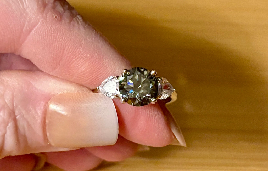 Moissanite ring. A 3ct certified GRAY Moissanite with 1.5cttw of heart-cut white zircons, set in a sterling silver basket 3-stone design!