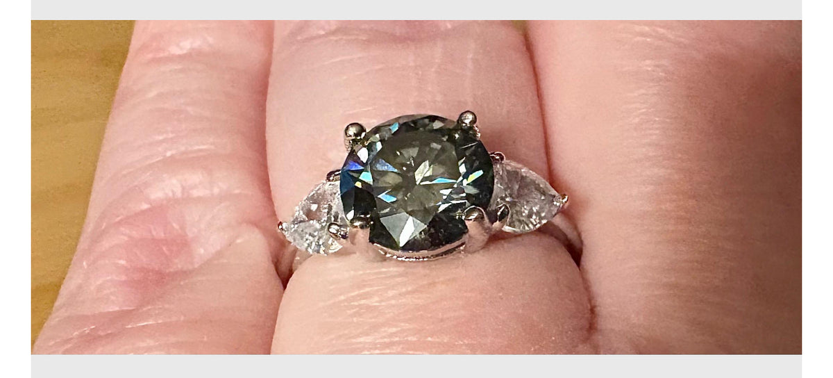 Moissanite ring. A 3ct certified GRAY Moissanite with 1.5cttw of heart-cut white zircons, set in a sterling silver basket 3-stone design!