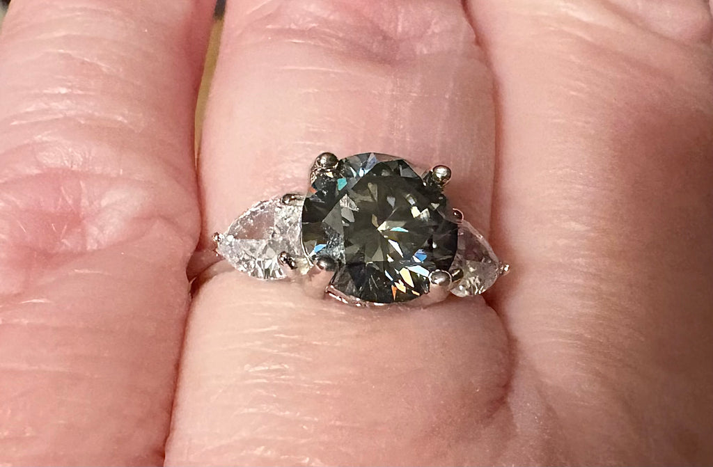 Moissanite ring. A 3ct certified GRAY Moissanite with 1.5cttw of heart-cut white zircons, set in a sterling silver basket 3-stone design!