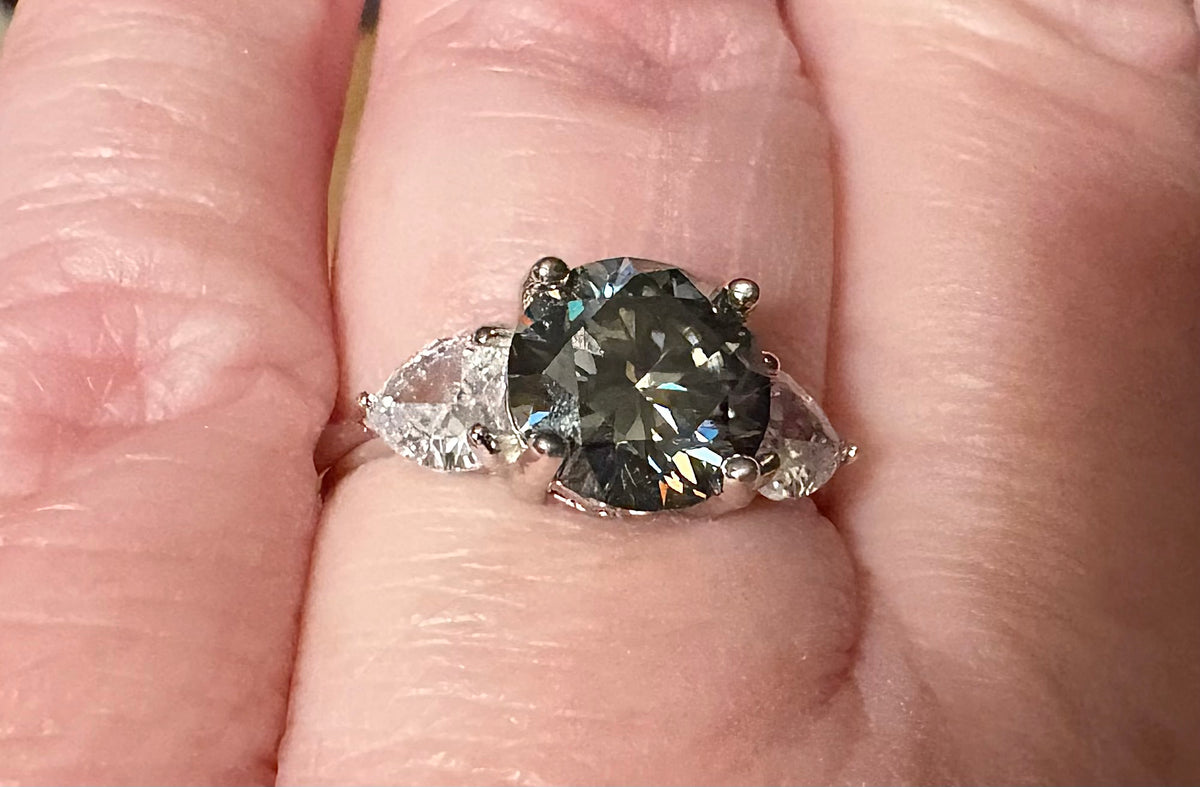Moissanite ring. A 3ct certified GRAY Moissanite with 1.5cttw of heart-cut white zircons, set in a sterling silver basket 3-stone design!