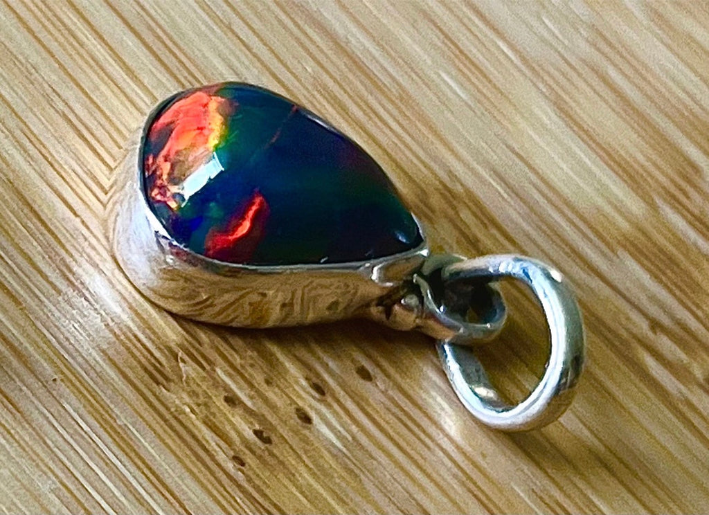 2.99ct Ethiopian opal pendant. AAA grade smoked opal cabochon pear in solid sterling silver. This flashy stone measures 9.6mm x 13mm!