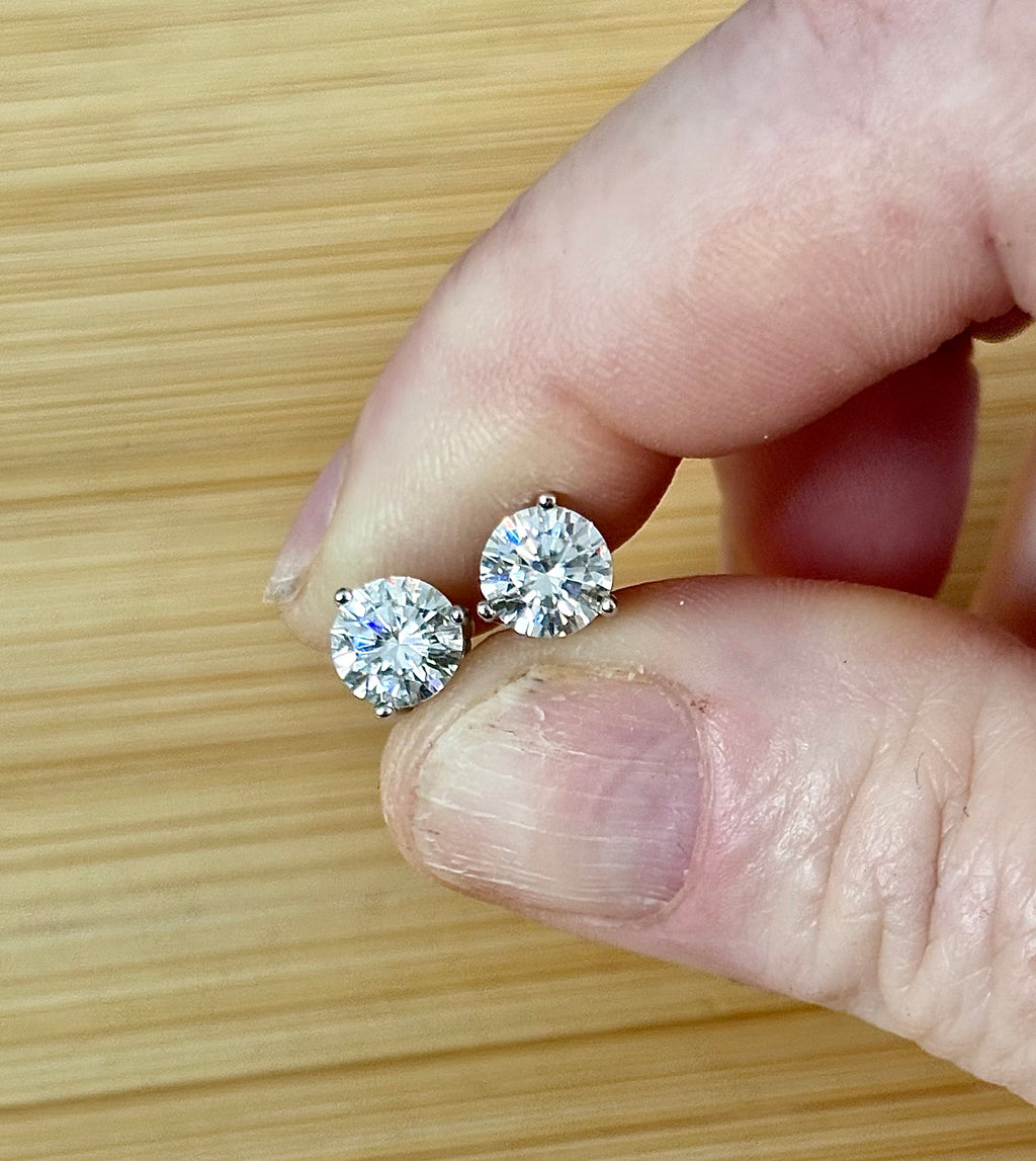 Moissanite earrings. A delicate certified 2cttw pair of 3-prong or 4-prong round brilliant Moissanites in 18k gold-embraced sterling silver baskets! Classic!