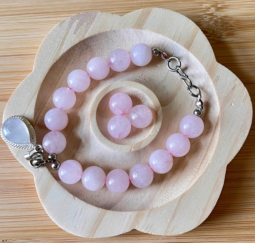 Madagascar rose quartz bracelet. 10mm beads with stainless steel components. The featured sterling silver pendants are sold separately.