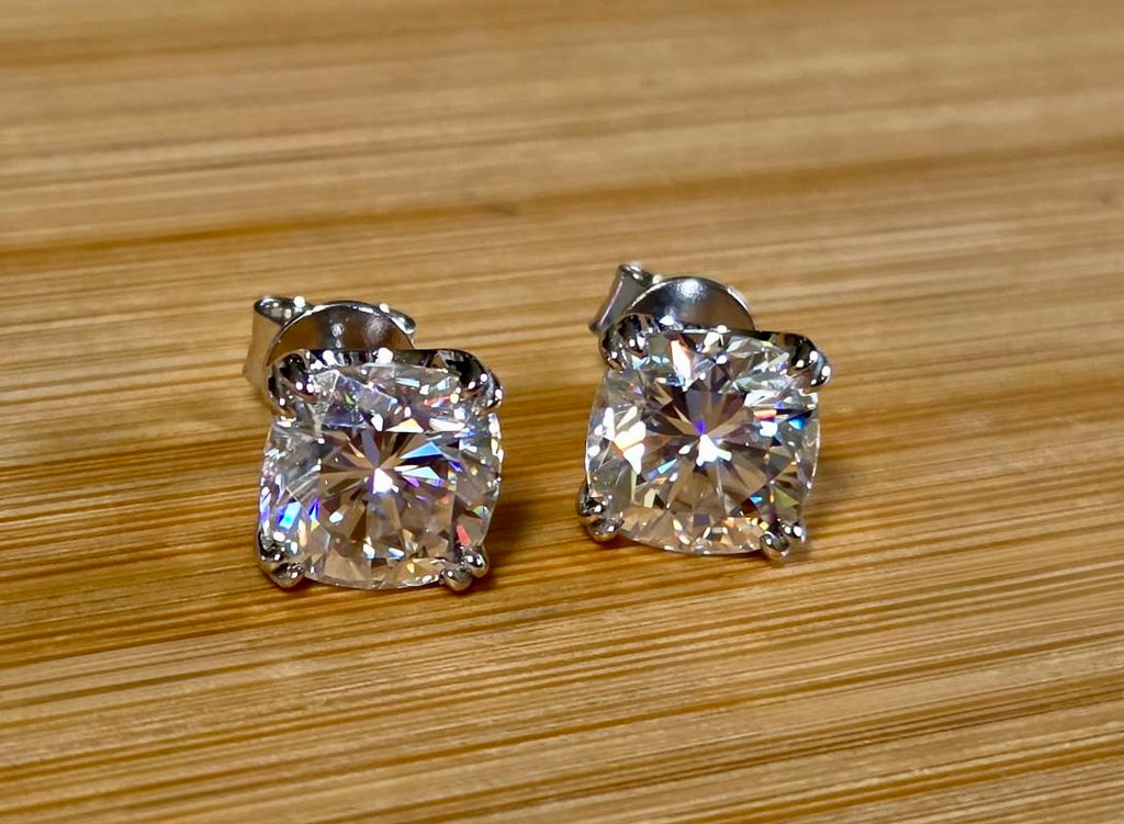 6ctw cushion-cut Moissanite studs in elegant sterling silver double-claw mountings! With brilliant faceting, these earrings are showstoppers!