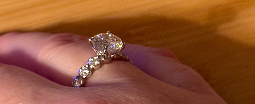 A 3.8cttw designer Moissanite ring with a certified 3ct center stone and 10-point bezel-set stones in sterling silver and 18k gold!