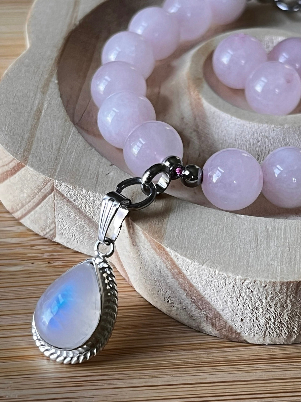 Madagascar rose quartz bracelet. 10mm beads with stainless steel components. The featured sterling silver pendants are sold separately.