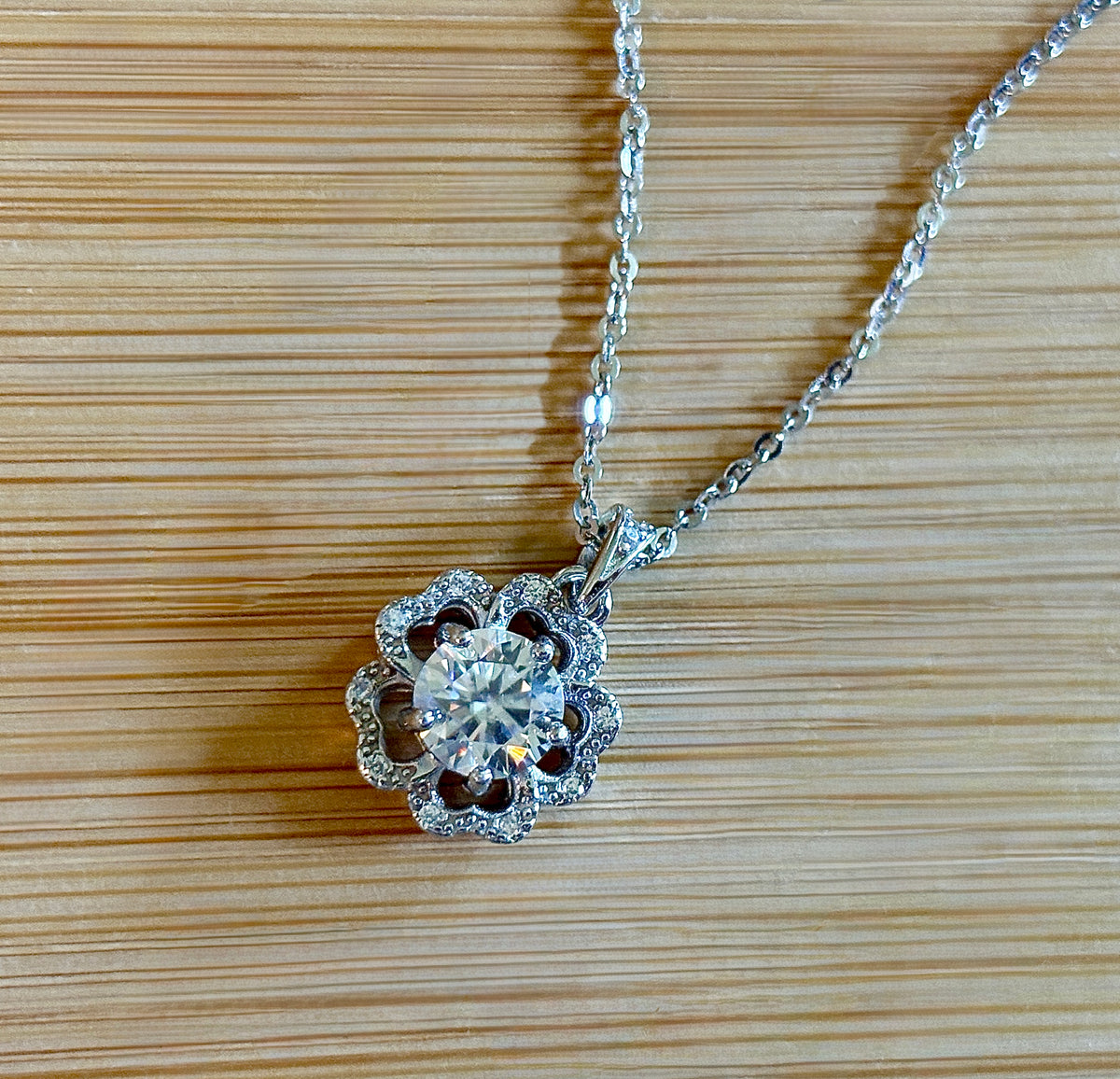 Moissanite necklace. A certified 1ct Moissanite hibiscus necklace with white zircon accents in solid sterling and white rhodium!