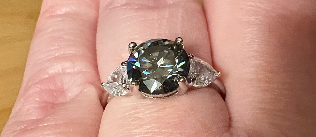 Moissanite ring. A 3ct certified GRAY Moissanite with 1.5cttw of heart-cut white zircons, set in a sterling silver basket 3-stone design!