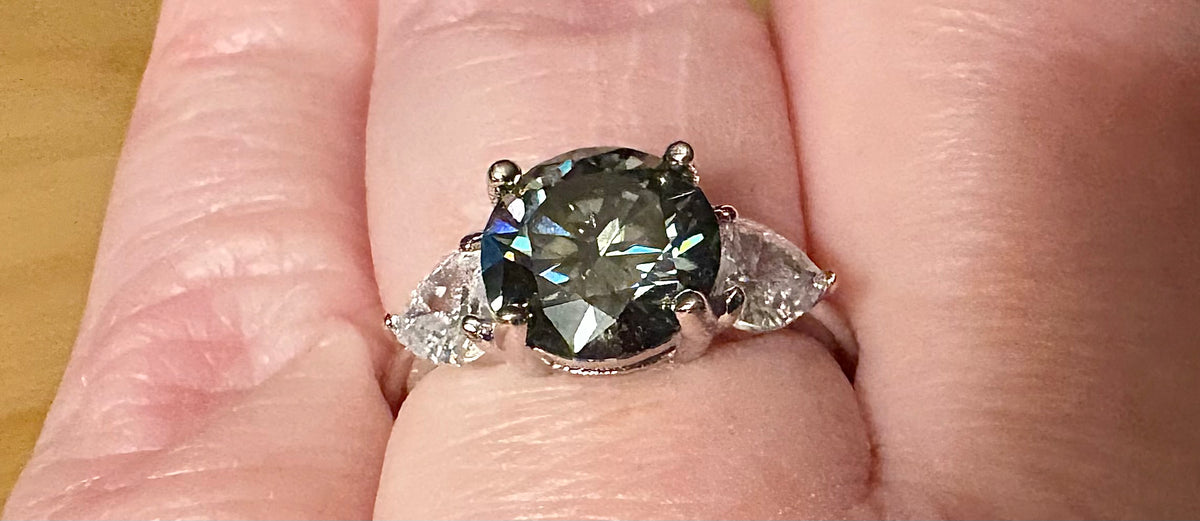 Moissanite ring. A 3ct certified GRAY Moissanite with 1.5cttw of heart-cut white zircons, set in a sterling silver basket 3-stone design!