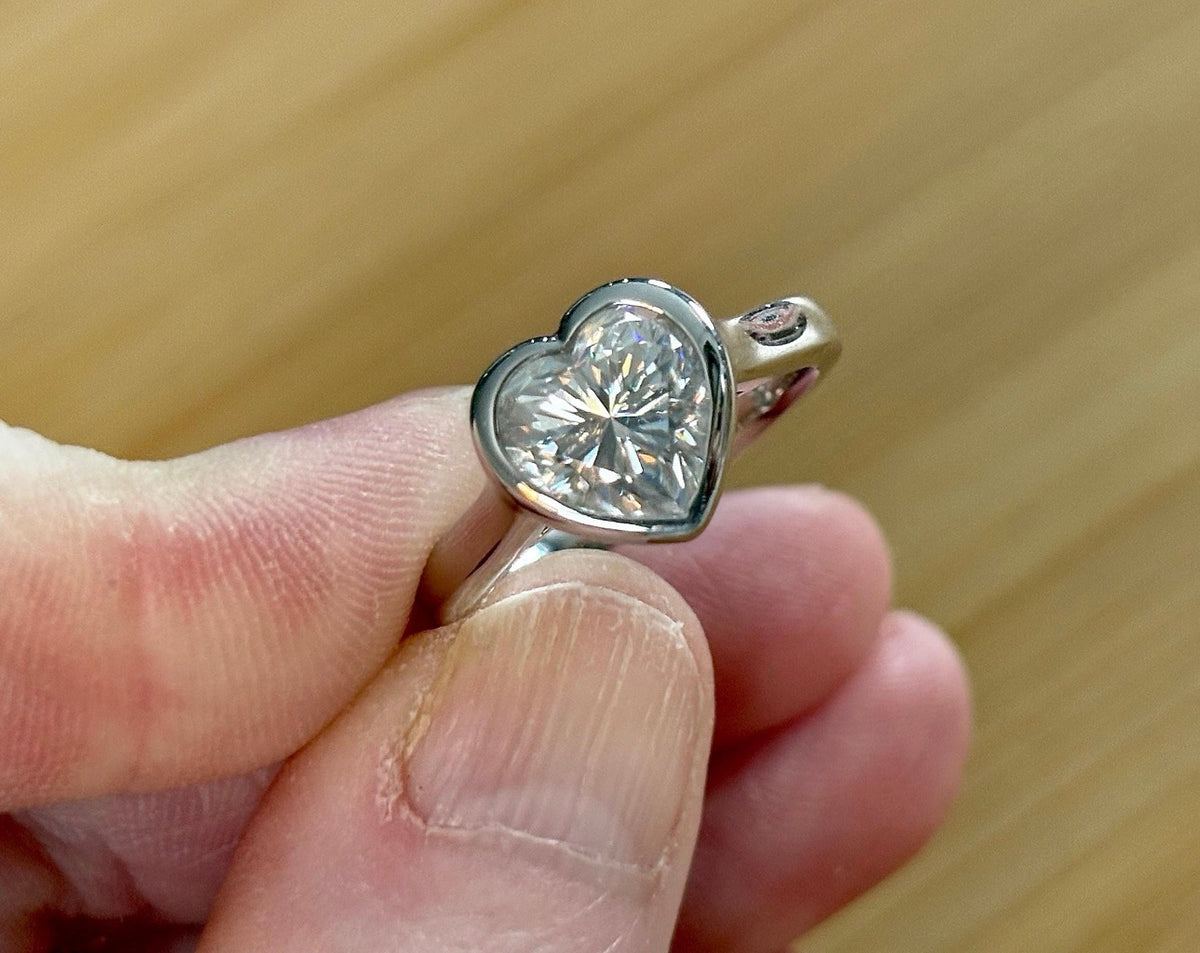 Moissanite ring. A high-end solitaire with a certified 3ct heart-cut stone, bezel-set in a heavy sterling silver mounting and bathed in 18k!