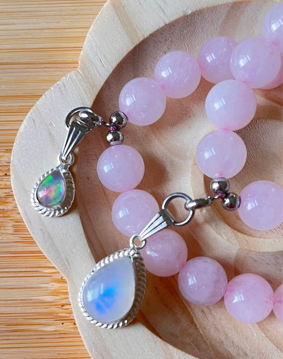 Madagascar rose quartz bracelet. 10mm beads with stainless steel components. The featured sterling silver pendants are sold separately.