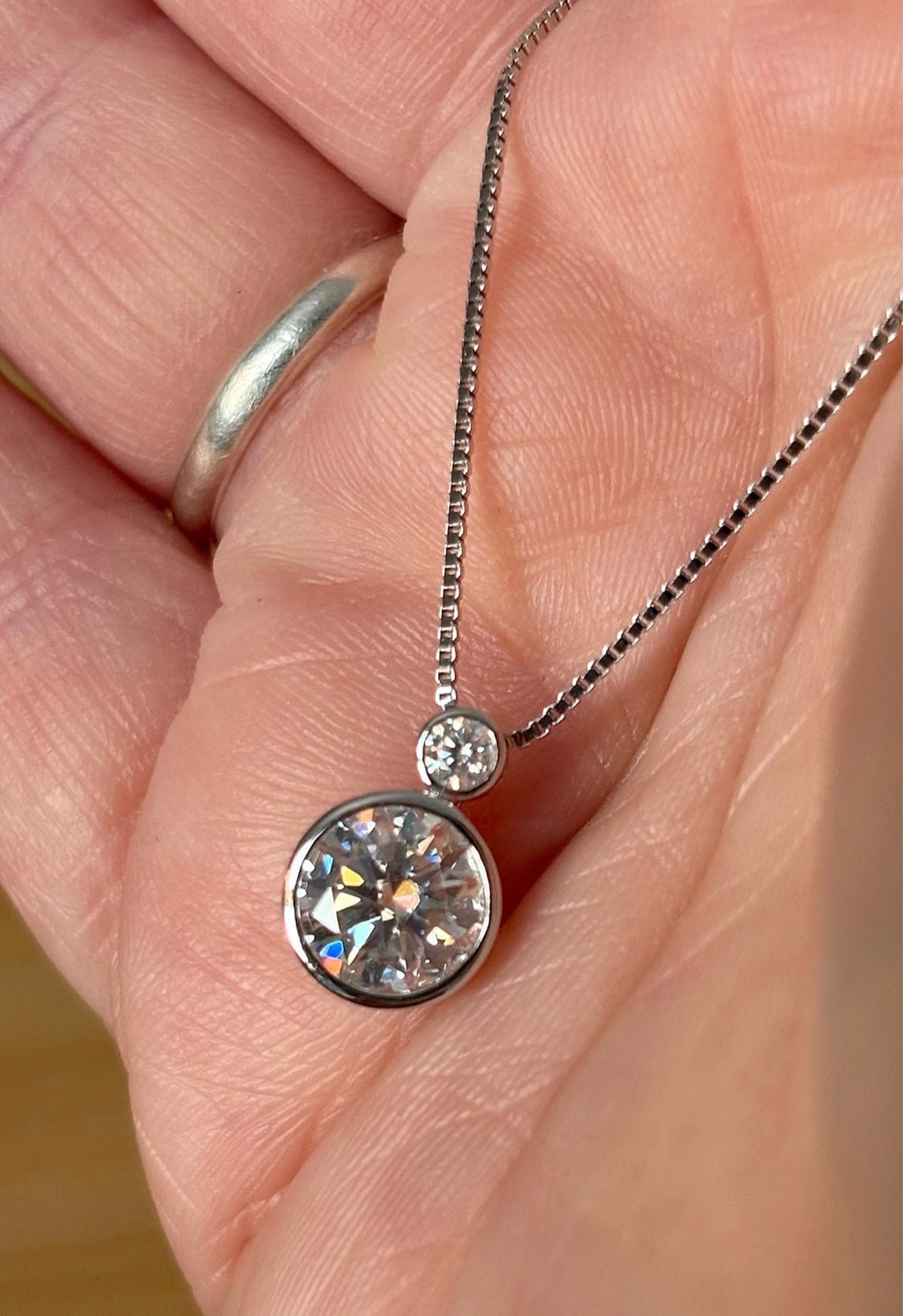 Moissanite necklace. A bright 2.1ctw certified Moissanite bezel pendant, with a 18” box chain and lobster claw clasp in sterling silver!