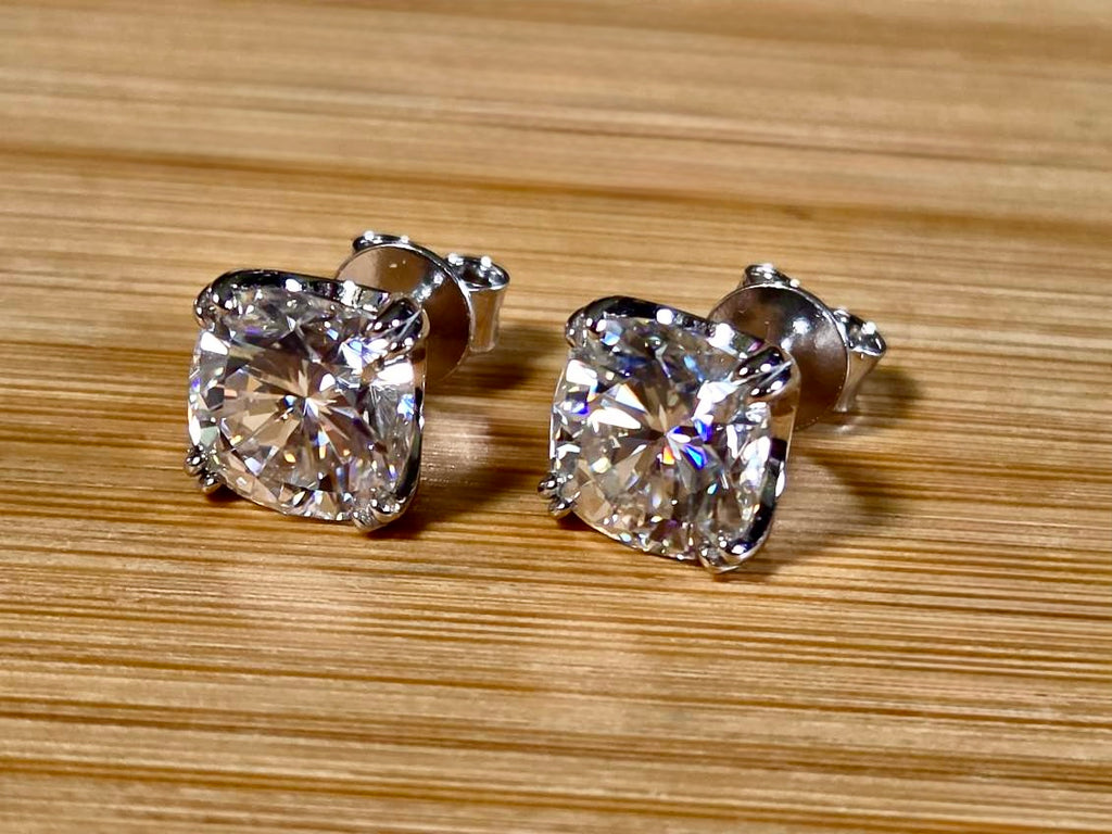 6ctw cushion-cut Moissanite studs in elegant sterling silver double-claw mountings! With brilliant faceting, these earrings are showstoppers!
