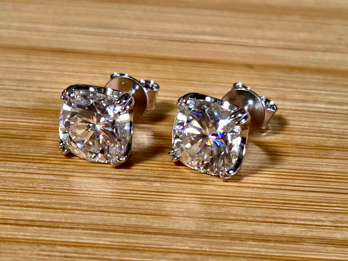 6ctw cushion-cut Moissanite studs in elegant sterling silver double-claw mountings! With brilliant faceting, these earrings are showstoppers!