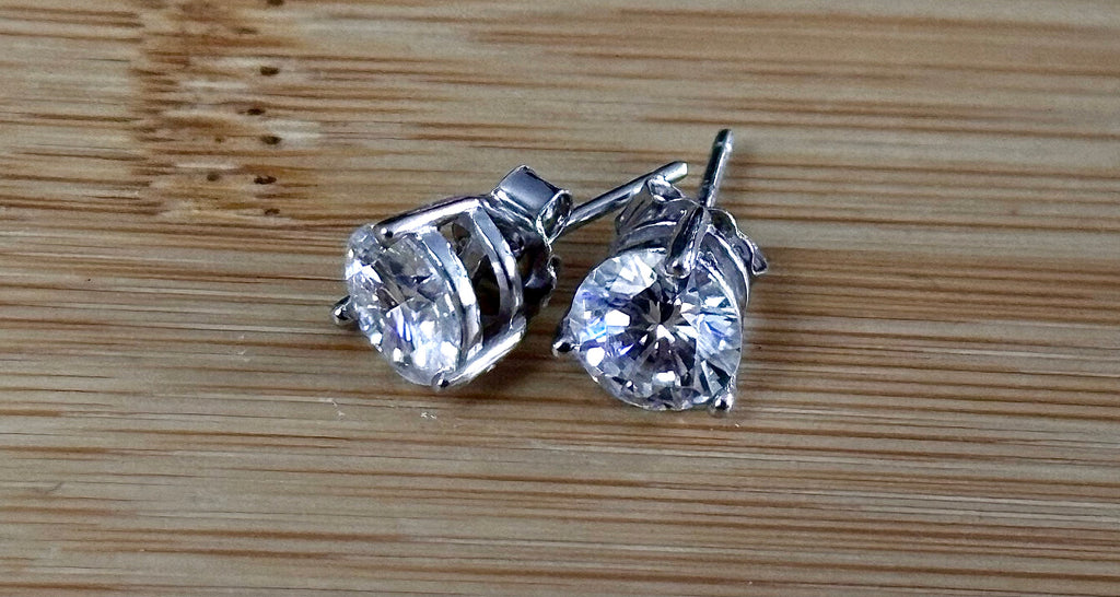 Moissanite earrings. A delicate certified 2cttw pair of 3-prong or 4-prong round brilliant Moissanites in 18k gold-embraced sterling silver baskets! Classic!