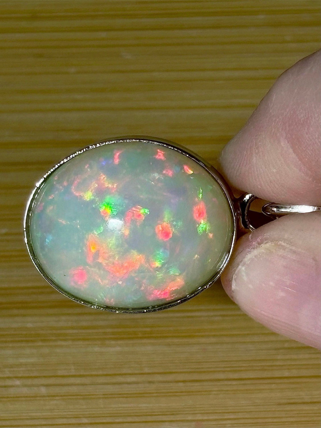 A 17.28ct AAA grade Ethiopian opal pendant with multi-patterned fire and beautiful play of color, hand-picked by Hand Knotted Jewelry!