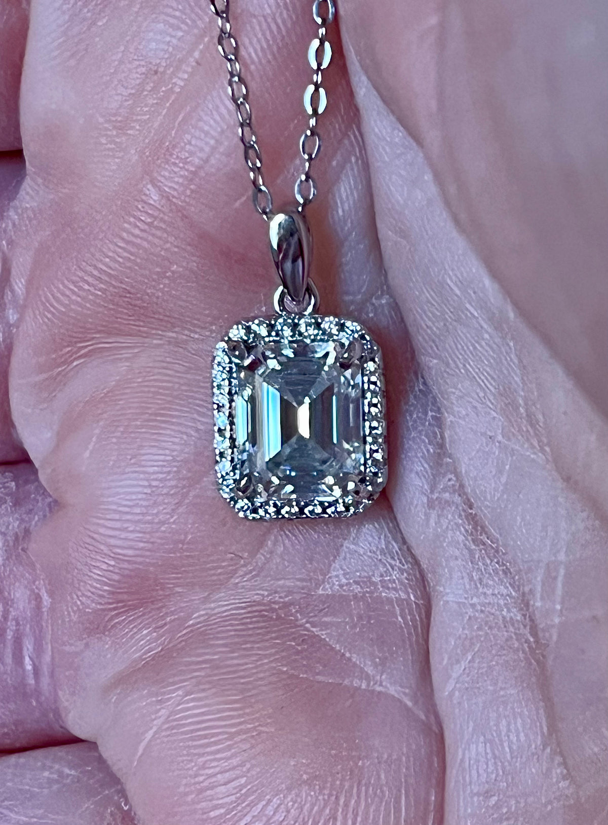 Moissanite necklace. An elegant 3ct certified emerald-cut Moissanite within a halo of shining white zircons, in 18k gold-embraced sterling!