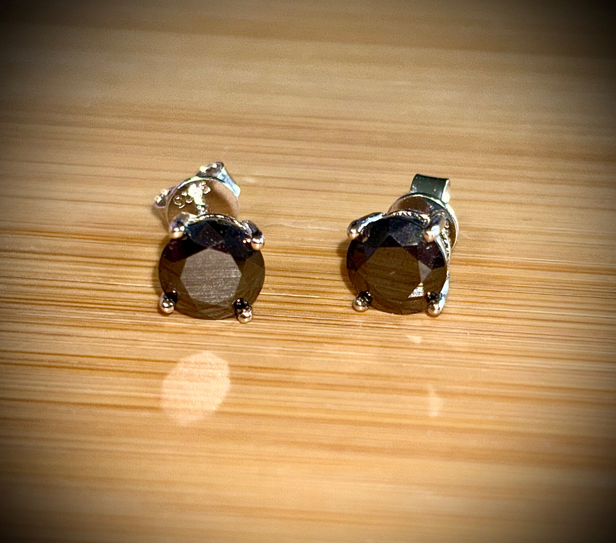 Moissanite studs. A 2cttw certified pair of black Moissanite studs in a sterling silver basket setting with 18k white gold plating!