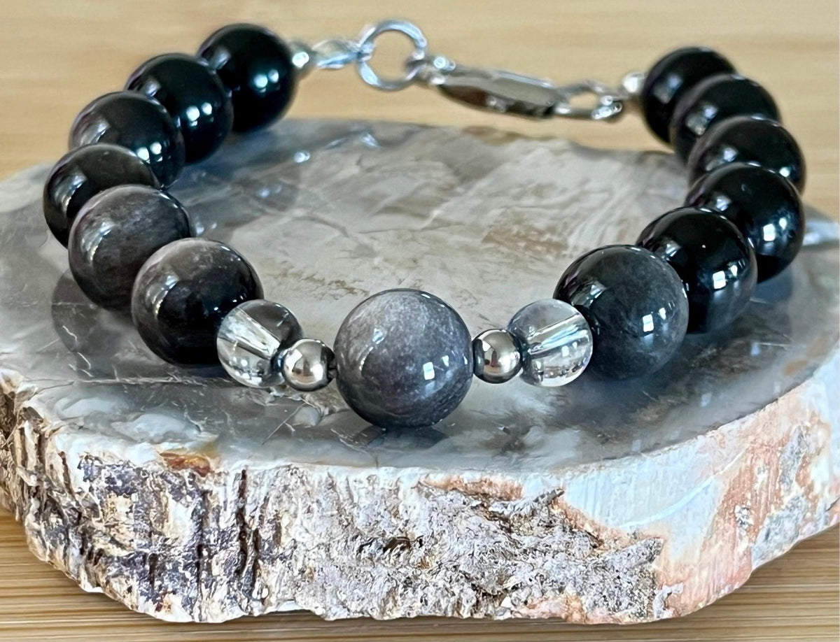 Silver sheen obsidian and clear quartz bracelet and earrings. Pair the “Silver Bells” bracelet and/or earrings with your little black party dress and be the Belle of the Ball!