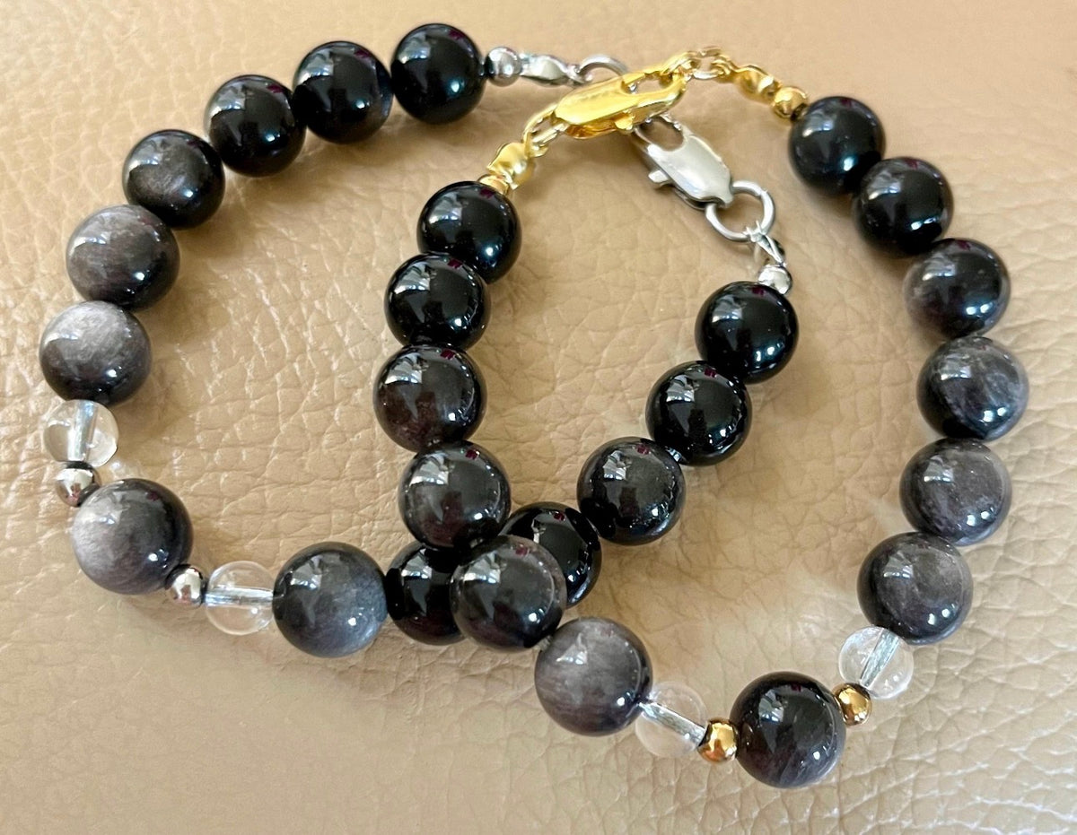 Silver sheen obsidian and clear quartz bracelet and earrings. Pair the “Silver Bells” bracelet and/or earrings with your little black party dress and be the Belle of the Ball!