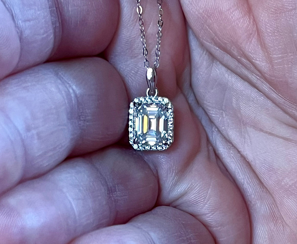 Moissanite necklace. An elegant 3ct certified emerald-cut Moissanite within a halo of shining white zircons, in 18k gold-embraced sterling!