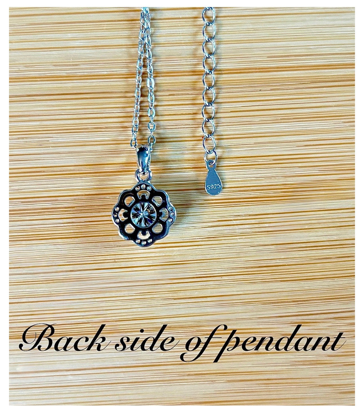 Moissanite necklace. With a floral motif, this pendant features a 1ct Moissanite nestled within alternating “petals” of silver and zircons!