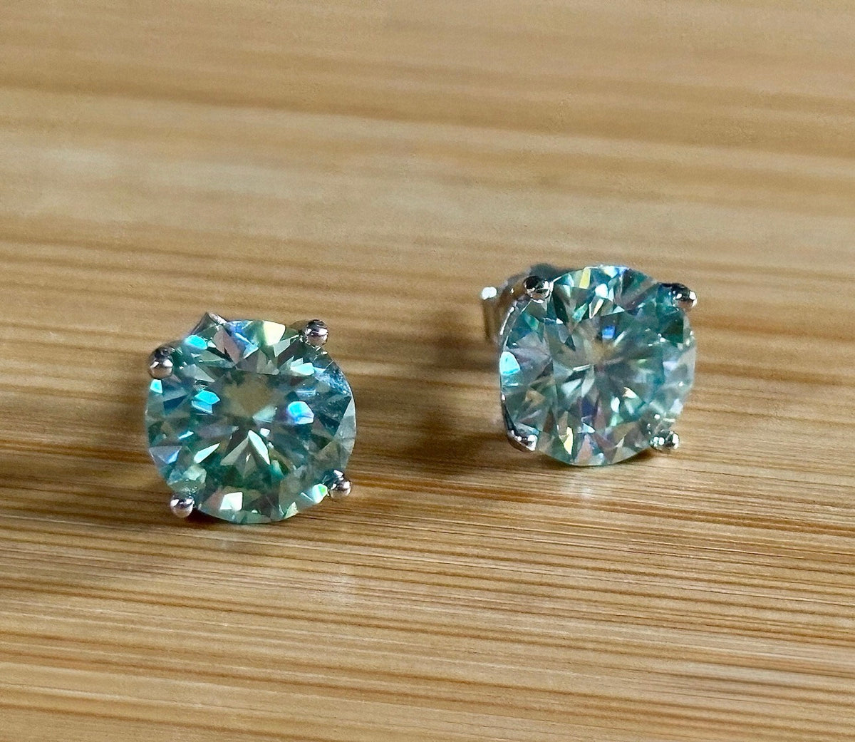 Moissanite earrings. A 6ctw certified pair of true icy baby blue Moissanite studs in sterling silver baskets with gleaming white rhodium!