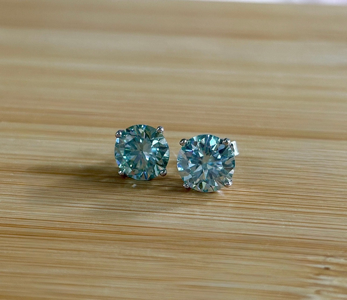 Moissanite earrings. A 6ctw certified pair of true icy baby blue Moissanite studs in sterling silver baskets with gleaming white rhodium!