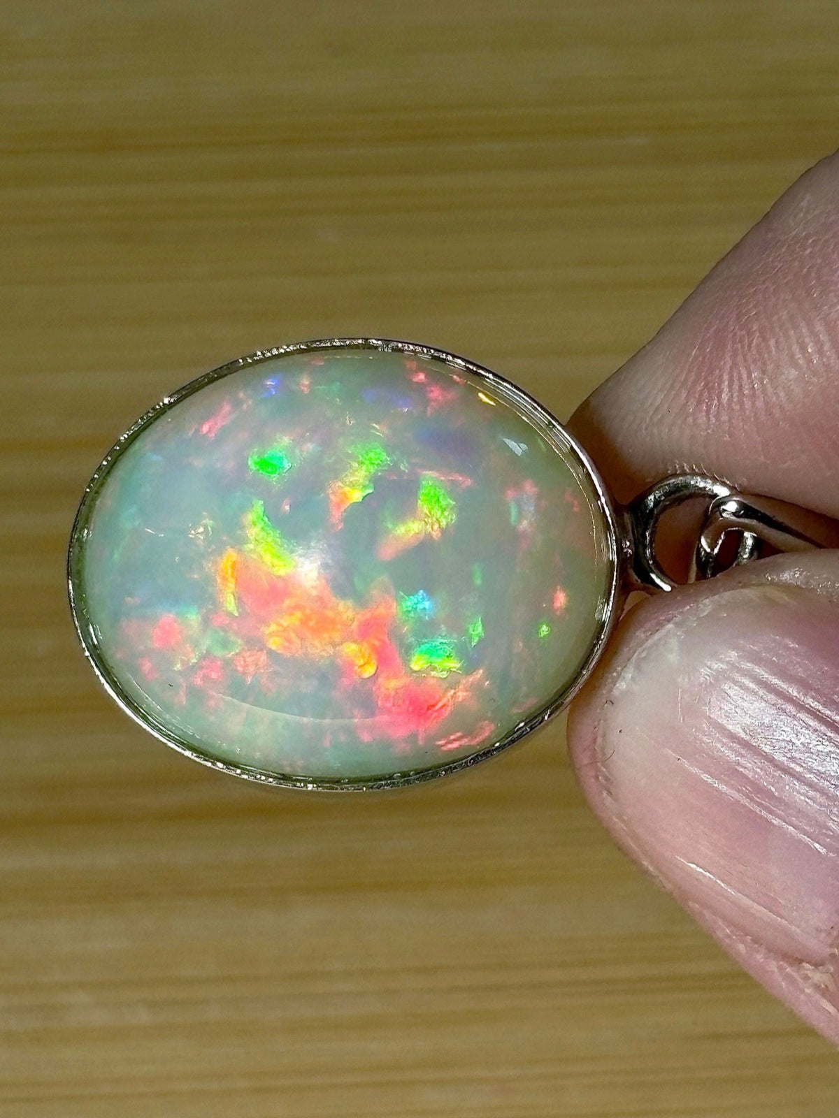 A 17.28ct AAA grade Ethiopian opal pendant with multi-patterned fire and beautiful play of color, hand-picked by Hand Knotted Jewelry!