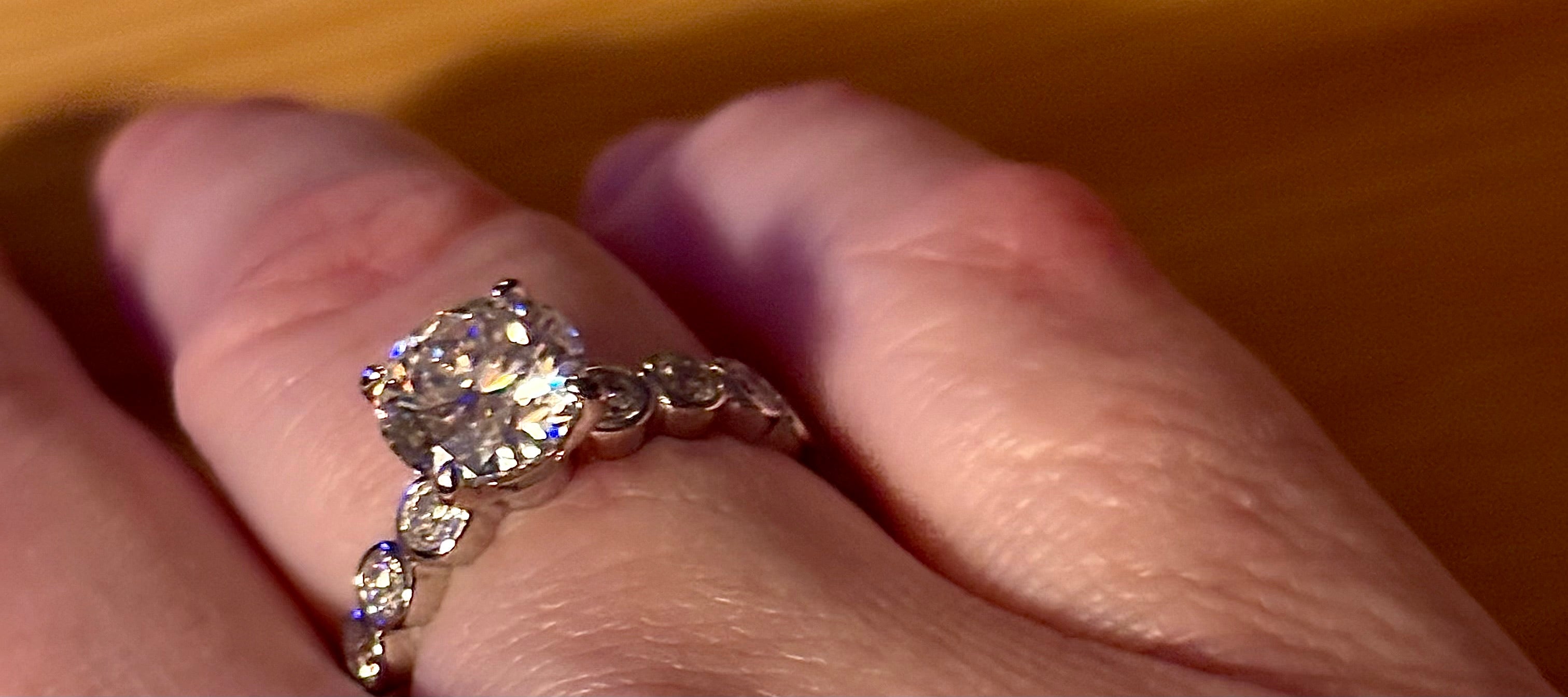 A 3.8cttw designer Moissanite ring with a certified 3ct center stone and 10-point bezel-set stones in sterling silver and 18k gold!