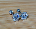 A certified pair of pretty, floral-inspired 2cttw or 4cttw Moissanite studs in poinsettia-shaped settings w/screwball backs OR 4cttw w/push backs!