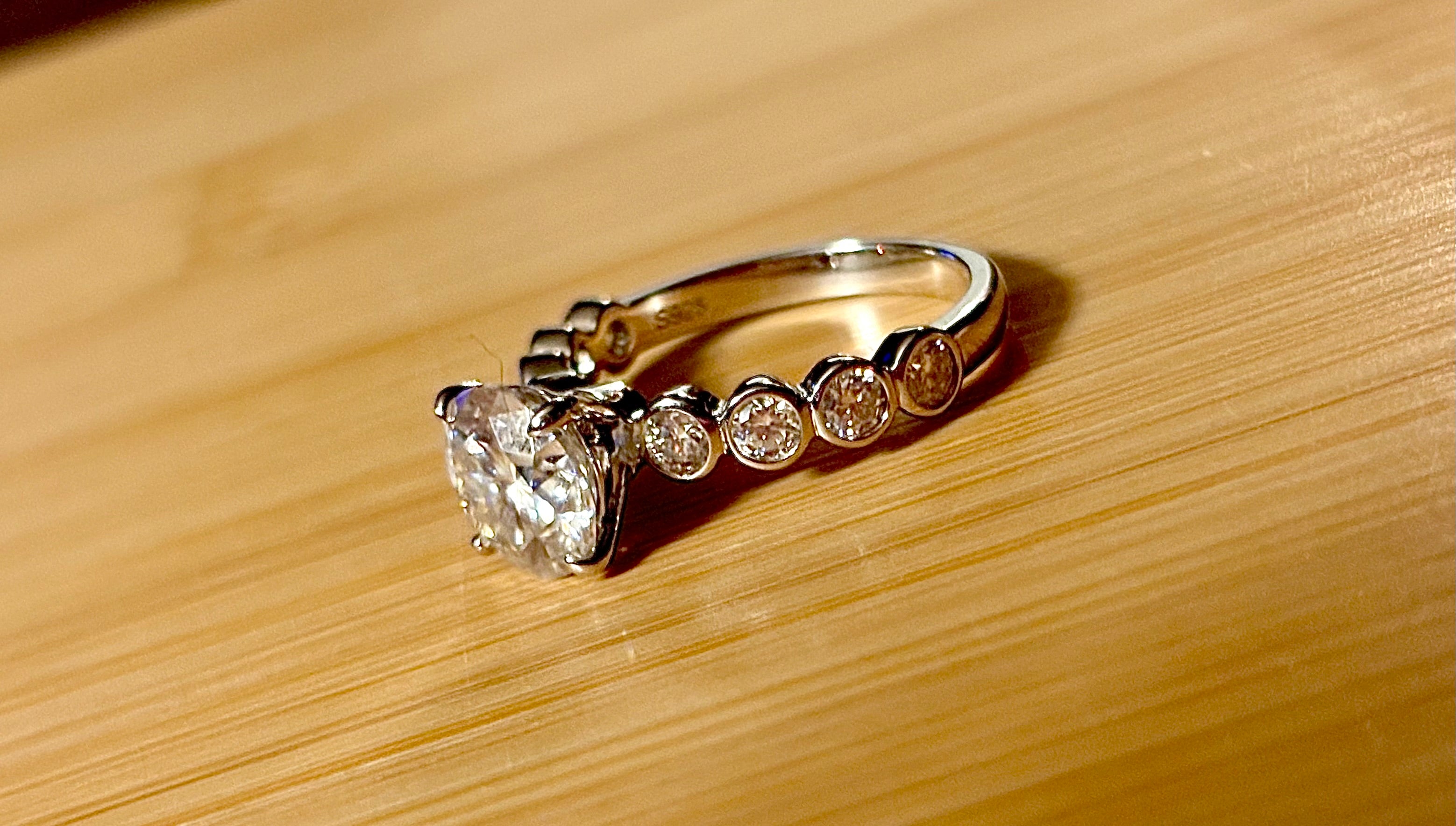 A 3.8cttw designer Moissanite ring with a certified 3ct center stone and 10-point bezel-set stones in sterling silver and 18k gold!
