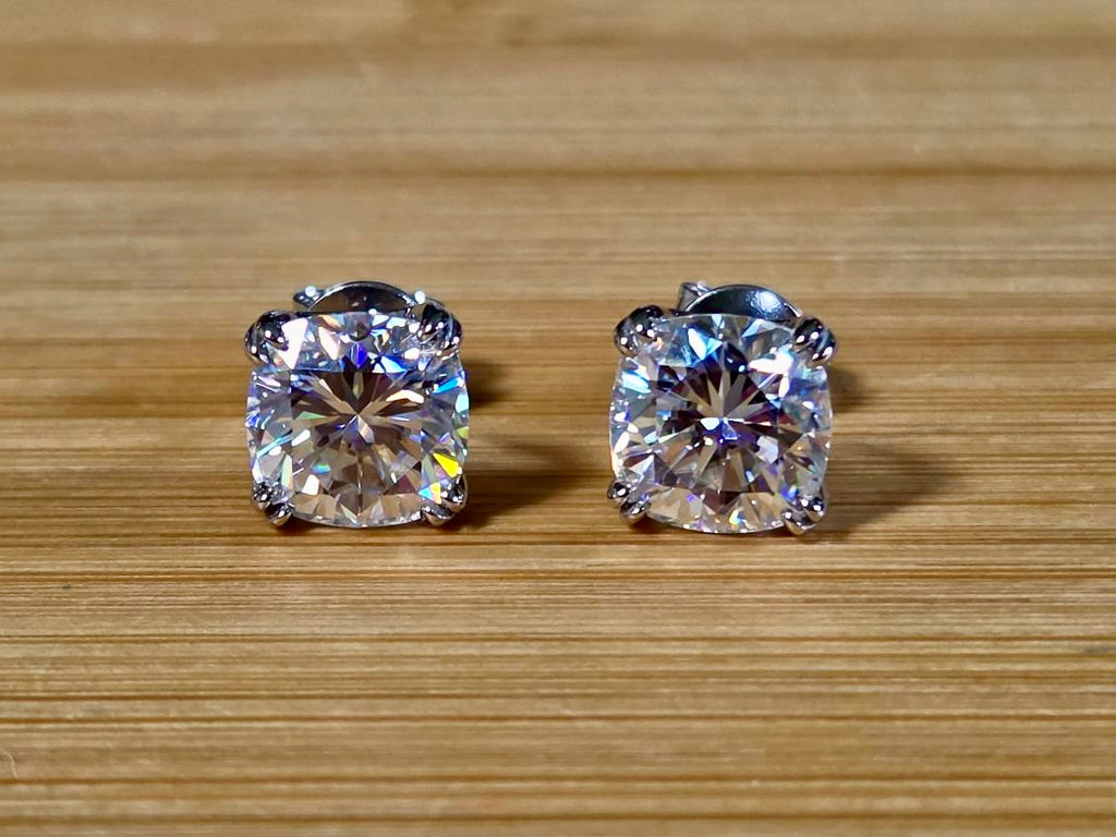6ctw cushion-cut Moissanite studs in elegant sterling silver double-claw mountings! With brilliant faceting, these earrings are showstoppers!