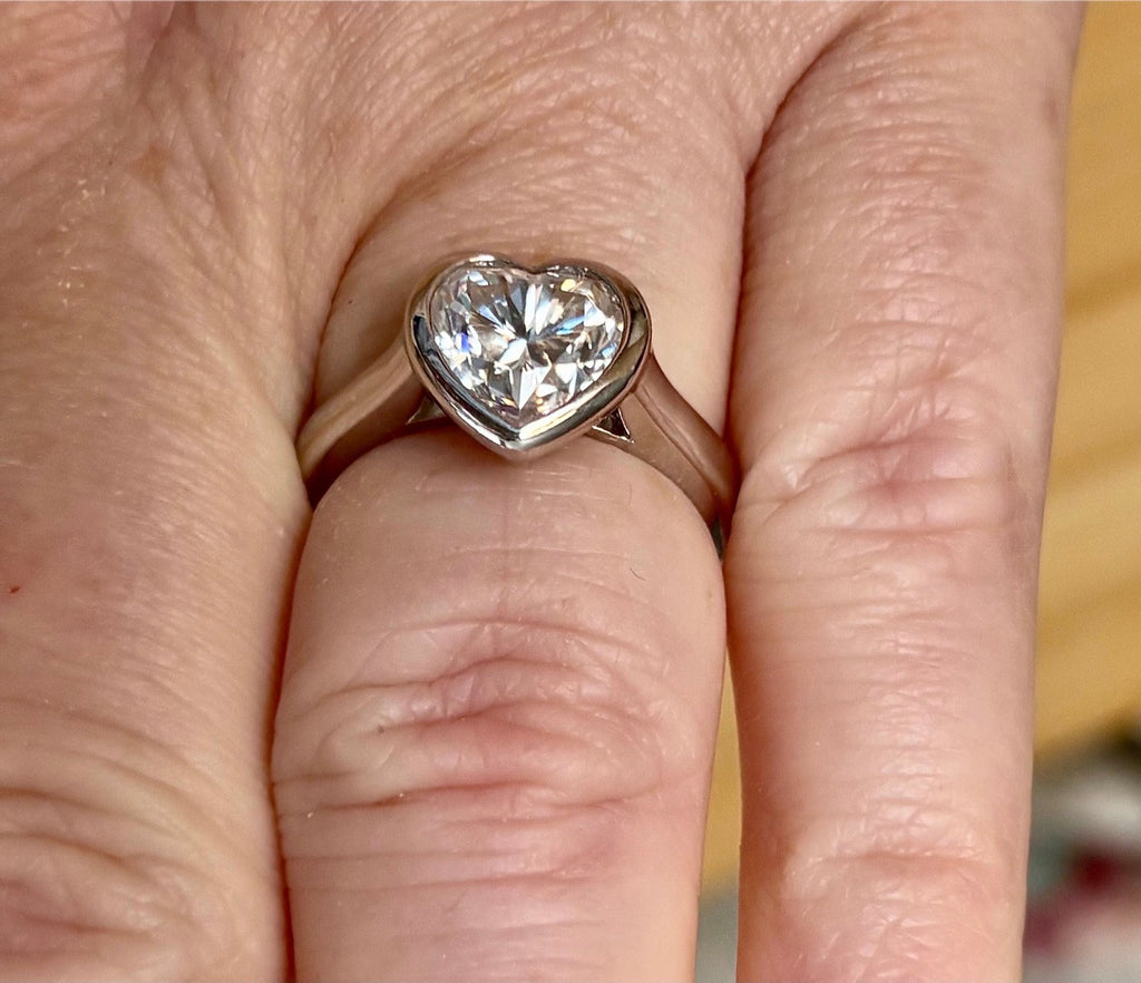 Moissanite ring. A high-end solitaire with a certified 3ct heart-cut stone, bezel-set in a heavy sterling silver mounting and bathed in 18k!