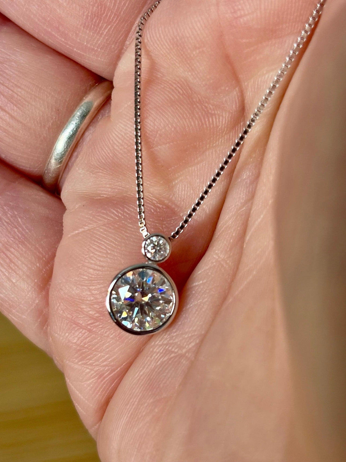 Moissanite necklace. A bright 2.1ctw certified Moissanite bezel pendant, with a 18” box chain and lobster claw clasp in sterling silver!