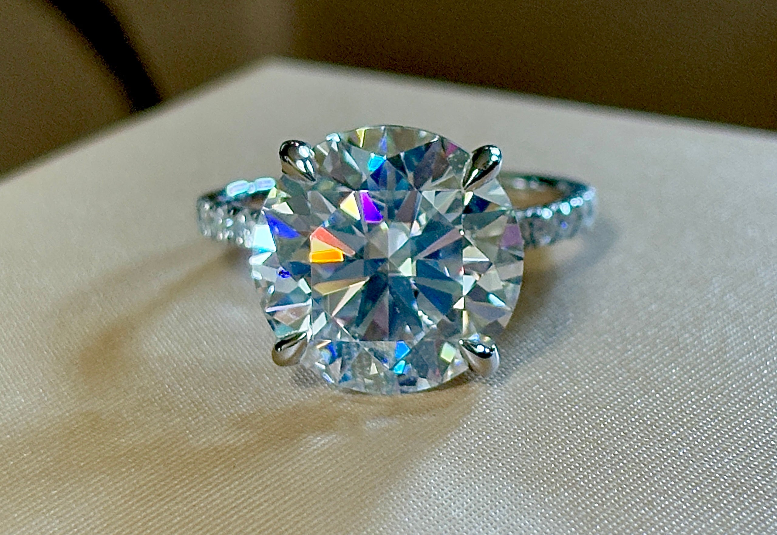 Moissanite solitaire. A glorious 10ct 8H8A Moissanite in a 4-prong mounting with a Moissanite “hidden halo” and shoulders, an 11.3cttw ring!